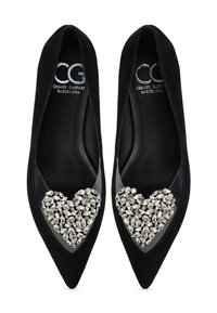 Černé semišové baleríny s špičatou špičkou, zdobené srdíčkovou aplikací z čirých rhinestones na nártu. Hladká podšívka.