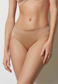 Nude seamless bikini ondergoed met een zachte, gladde textuur en een low-rise ontwerp. Elastische tailleband, minimale bedekking en geen zichtbare naden.