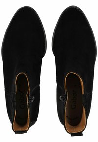 Bottines en suède noir avec un bout arrondi, fermeture éclair latérale et doublure beige. Présentent des accents matériels minimaux et une texture lisse.