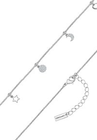 Sudraba aproce ar regulējamu ķēdīti, kurai ir zvaigzne, pusmēness un apaļa, apzeltīta piekariņa ar akcentiem. Iekļauts aizdare un zīmola birka.