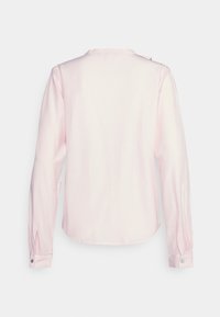 Chemise rose pâle à manches longues avec un col rond, un bouton à l'épaule et des manches à revers. Tissu lisse avec un léger éclat.