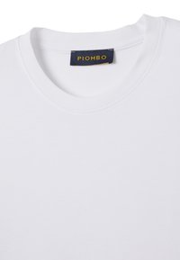 T-shirt bianca a girocollo con etichetta blu navy cucita all'interno del colletto, con la scritta gialla "PIOMBO".