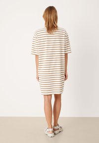 Gestreepte katoenen t-shirt jurk in crème en bruin, korte mouwen, recht gesneden, boven de knie vallend, met een ontspannen pasvorm en minimaliStisch ontwerp.