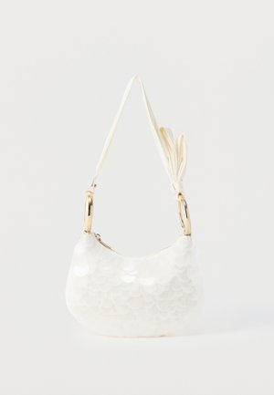 Hvid skuldertaske med store cirkulære palietter, guldfarvede metalringe som håndtag og en knyttet stofrem mod en ensfarvet baggrund.