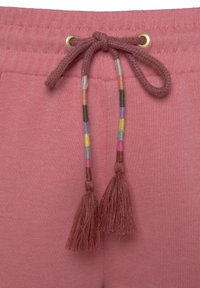 Roze katoenen sweatpants met een trekkoord, voorzien van meerkleurige geweven accenten en franjes. Zachte textuur en een elastische tailleband.