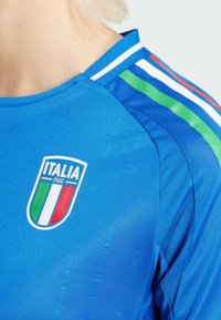 Sininen urheilupaita, jossa on vihreät, valkoiset ja punaiset raidat, pyöreä kaula-aukko ja Italia FIGC -logo rinnassa.