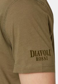 T-shirt verde oliva realizzato in cotone morbido con maniche corte, caratterizzato da cuciture a contrasto e dettaglio stampato "DIAVOLI ROSSI" sulla manica.