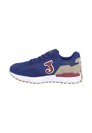 Zapatilla azul marino con talón beige, logo "J" burdeos en el lateral, suela blanca con motas de colores, y suela exterior marrón texturizada.