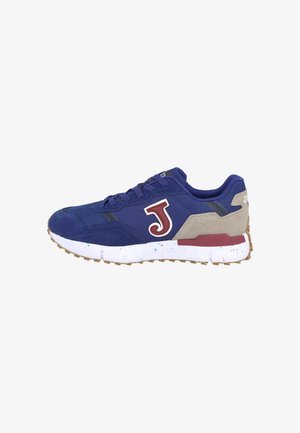 Zapatilla azul marino con talón beige, logo "J" burdeos en el lateral, suela blanca con motas de colores, y suela exterior marrón texturizada.