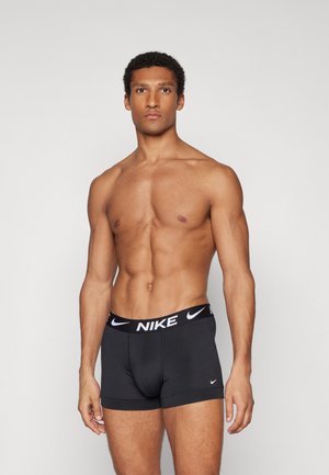 Schwarze Nike Boxershorts mit dicker schwarzer Taille und weißem Logo. Enganliegendes Design, glatte Textur und kurze Beininlength.