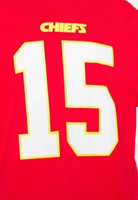 Camiseta de algodón roja con "CHIEFS" en amarillo sobre un gran número blanco "15" contorneado en amarillo. Espalda lisa.