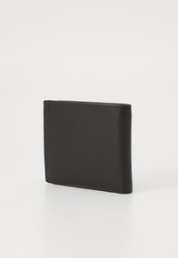 Crni kožni novčanik slim, pravokutnog oblika. Glatka tekstura, čiste ivice i suptilne šavove na stranama.