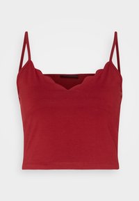 Top corto rojo con tirantes delgados ajustables, que presenta un escote con volantes y una textura suave y ligeramente elástica.