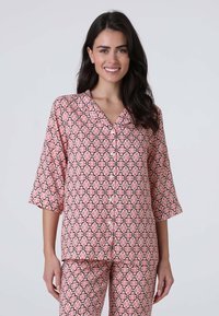 Completo pigiama rosa a fantasia con maniche a tre quarti; presenta motivi floreali contornati di nero. Tessuto morbido con chiusura a bottoni davanti.