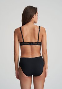 Zwarte bh en hooggezette slipset, met gegolfde randen, verstelbare bandjes en een haak-en-oogsluiting op de rug.