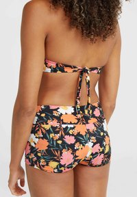 Bloemen bikini set met een zwarte achtergrond en levendige oranje, roze en witte bloemen. Top met striksluiting en hoge tailleonderkant.