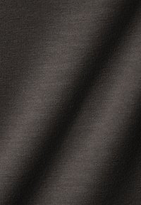 Melnas fakturētas audums ar gludu, ribotu virsmu un smalku spīdumu, attēlojot krokas, kas norāda uz elastību un mīkstumu.