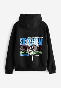 Crna majica s kapuljačom koja prikazuje grafički dizajn s šarenim tekstom: "STOCKHOLM SK8 COMP", dva cvijeta i naglaske u plavoj, ružičastoj, zelenoj i bijeloj boji.