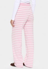Pyjamabroek in lichtroze met witte horizontale strepen, voorzien van een brede elastische tailleband en een comfortabele pasvorm met een gladde textuur.