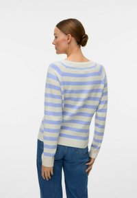 Maglione a righe color beige chiaro con strisce blu, scollo a giro, maniche lunghe e polsini a costina. Tessuto morbido, vestibilità casual e lunghezza media.