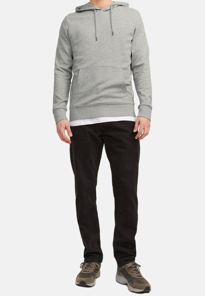 Gray hoodie with a front pocket, drawstrings, and ribbed cuffs, paired with black pants and gray sneakers. Textured, casual fabric.