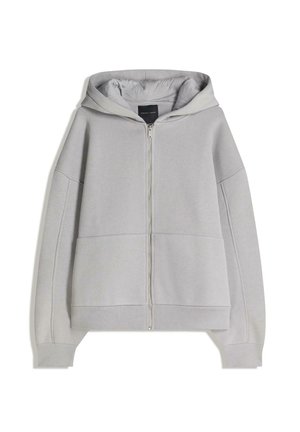 Hanorac gri cu fermoar, dotat cu un gluga reglabil, buzunare mari în față și manșete și tiv din material elastic. Fabricat dintr-un material moale și texturat.