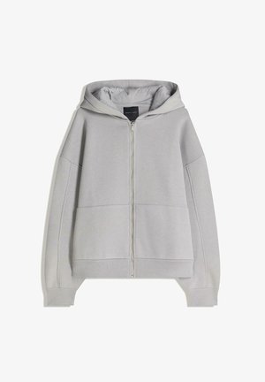 Hanorac gri cu fermoar, dotat cu un gluga reglabil, buzunare mari în față și manșete și tiv din material elastic. Fabricat dintr-un material moale și texturat.