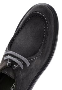Grijze suede schoen met een ronde neus, contrasterende grijze veters en witte stiksels langs de randen. Voorzien van een zwarte rubberen zool.