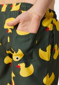 Groene shorts met een patroon van gele rubberen eenden met rode snavels. Inclusief een zijzak met een oogje details. Glad textiel.