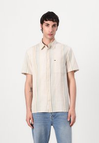 Kortermet skjorte med knapper i lys beige med vertikale striper i gr�ønn, gul og blå. Har en liten brystlomme og klassisk krage.