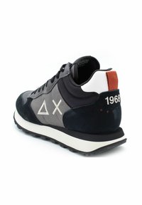 Czarne zamszowe i szare tekstylne sneakersy z białym logo, kontrastowym pomarańczowym uchwytem na pięcie oraz teksturowaną gumową podeszwą. Widoczny numer modelu 1968.