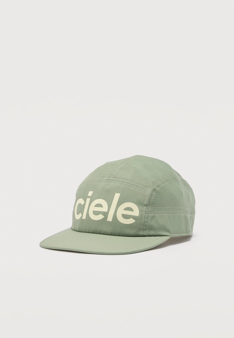 Cappellino in tessuto verde chiaro con visiera curva e la scritta "ciele" in grandi lettere bianche sul pannello frontale, mostrato su uno sfondo semplice.