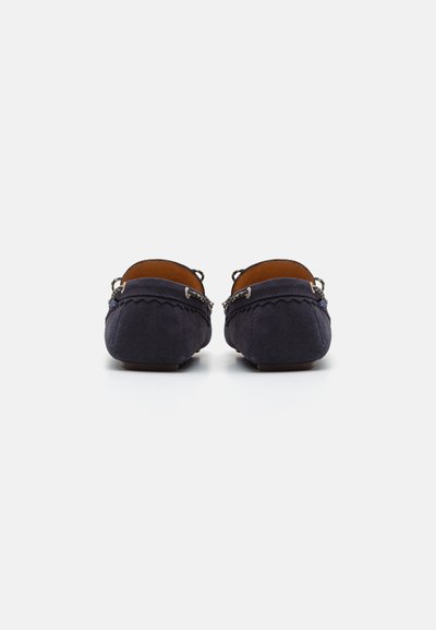 Marineblå ruskinds loafers med flad hæl, rund tå og dekorativ syning. Har metaldetaljer bagi. Blød tekstur.