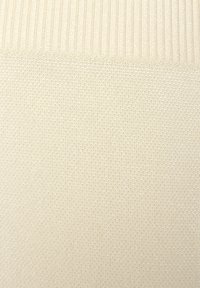 Lichtbeige gebreide stof met een ribbelstructuur aan de bovenkant en een gladde, gelijkmatige structuur eronder. Geen zichtbare patronen of accenten.