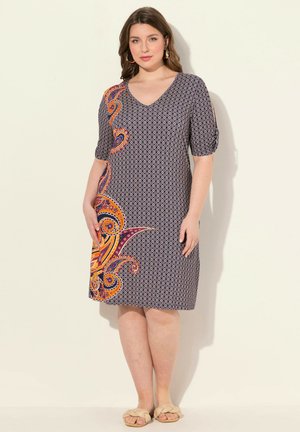 Lyhythihainen mekko tummansinisellä värillä, jossa on geometrinen kuvio ja eläväinen paisley-kuviointi oranssina ja purppurana sivussa. Sileää kangasta.