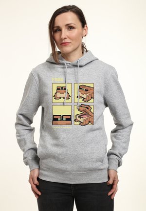 Szara bluza z kapturem z graficznym nadrukiem żab w czterech panelach, każda w różnych kolorach i wzorach. Materiał wydaje się miękki i ma luźny krój.