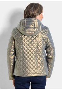 Gesteppten, kapuzenjacke aus metallisch goldenem Stoff; mit diamantenförmigen Nähten und taillierter Silhouette. Geeignet für kühles Wetter.