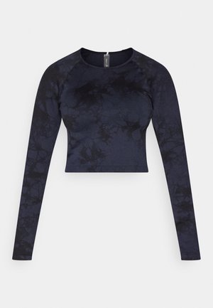 Langermet kort topp for kvinner i mørkeblå med svart batikkmønster og rund hals, vist flatt på hvit bakgrunn.