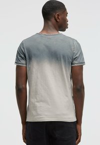 Men's short-sleeve t-shirt in gradient grey, featuring a round neckline, soft cotton material, and visible stitching detail along the hem.