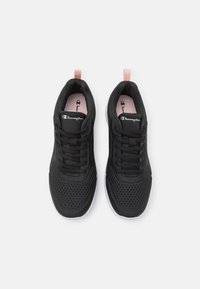 Svarta sportskor med övre i mesh, snörning och rosa dragflik. Har en vit sula. Champion-logotypen på plösen och sidan.