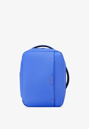 Sac à dos rectangulaire bleu avec poignées en haut et sur les côtés, design minimaliste et petit logo rouge sur la poche avant.
