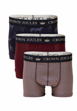 Drei Paare Boxer-Shorts: eine marineblaue mit Hunderaster, eine kastanienbraune und eine gestreifte in Rot und Weiß. Alle haben einen kontrastierenden, markenmäßigen Bund.