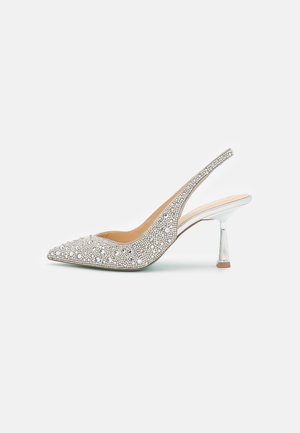 Chaussure à talon haut argentée à bride arrière avec bout pointu, décorée de petits et gros strass ronds, talon aiguille métallique.