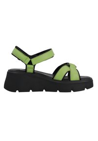 Sandales en simili cuir vert avec un design à brides croisées, semelle texturée noire et brides à la cheville réglables. Elles disposent d'une plateforme épaisse.