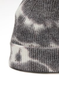 Gorro de punto gris y blanco con textura acanalada, que presenta un patrón suave y mezclado, y un dobladillo en la parte inferior.