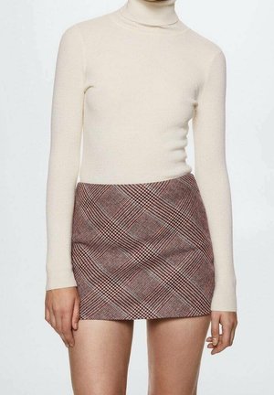 Haut à manches longues en côtes couleur crème avec col roulé, associé à une minijupe ajustée à carreaux dans des tons marron et rouge, présentant un tissu texturé et des lignes diagonales.