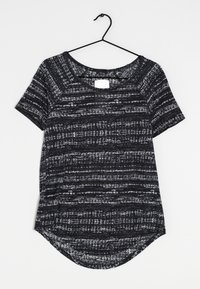Camisa de manga corta a rayas en blanco y negro con cuello redondo, que presenta un diseño de rayas texturizadas y un dobladillo curvado.