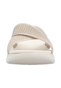 Beige slip-on sandals with a mesh upper featuring crisscross straps and a textured white rubber sole for grip and comfort.
