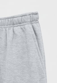 Grijze katoenen sweatpants met een elastische tailleband en een zachte textuur, voorzien van zichtbare stiksels en plooien rond de taille.