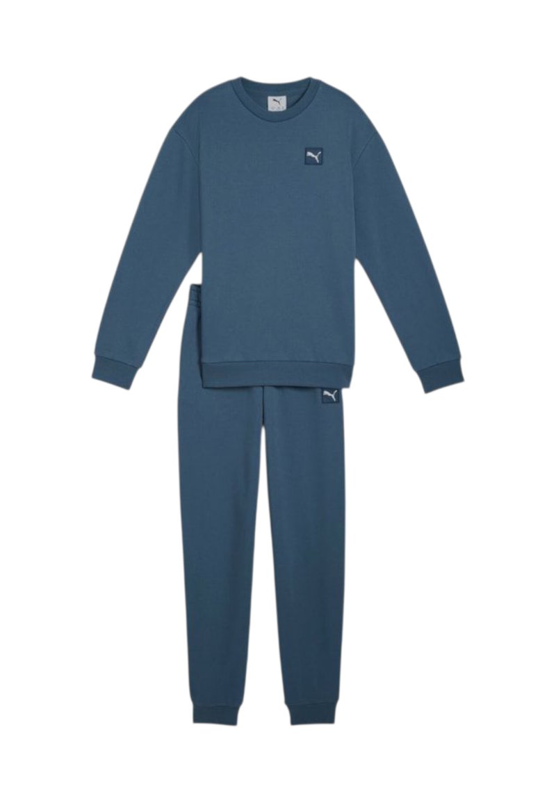 Completo felpa blu composto da felpa e pantaloni in tessuto morbido. Presenta polsini e orlo a costine, con una piccola etichetta logo su entrambi i pezzi.